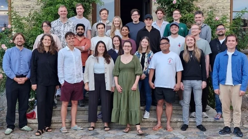 Das Team der Go Legal GmbH, rund 25 Personen, vor dem Eingang eines Backsteingebäudes